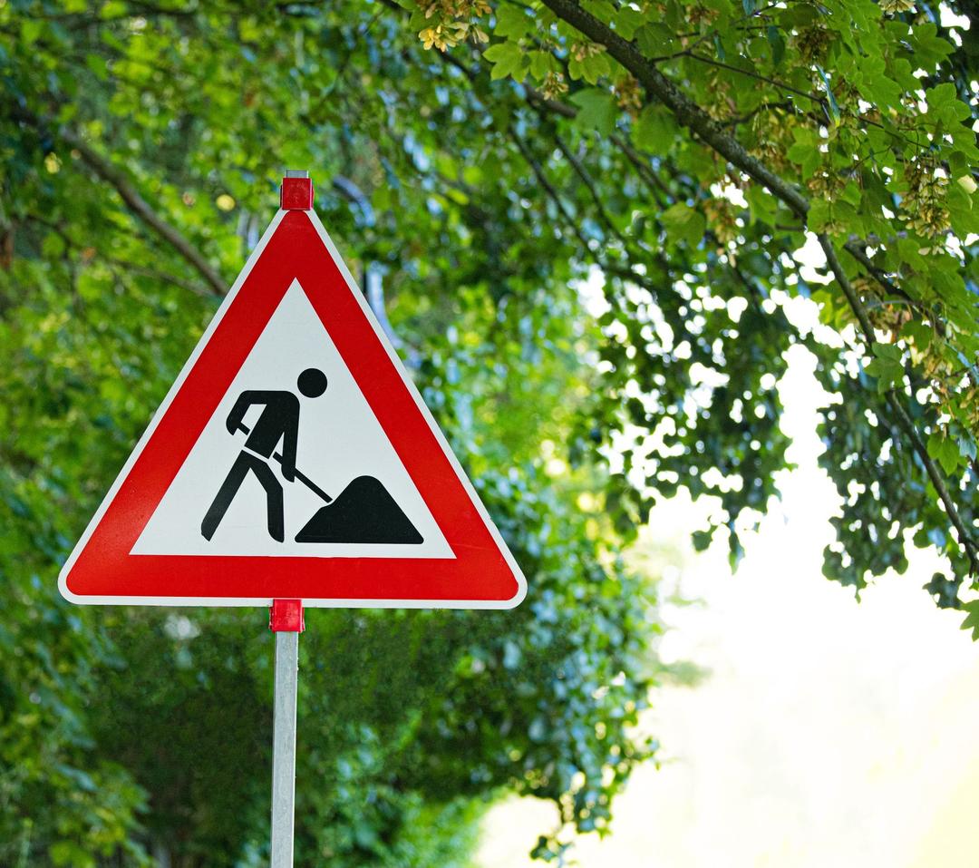 Baustellenbild vor grünem Baum.